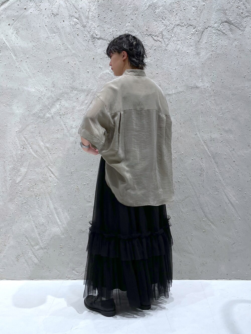 グリーン系のシャツ/ブラウス、ブラック系のスカートを着用したレディースの春コーディネートの2枚目の写真