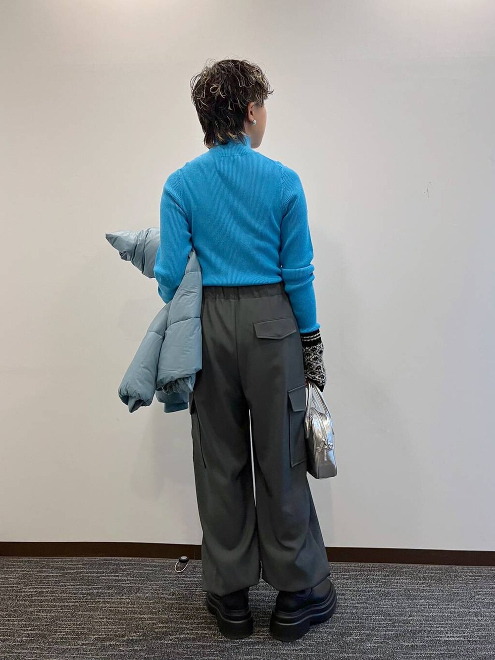 ブルー系のニット/セーター、ブルー系のブルゾン、ブラック系のブーツを着用したレディースの冬コーディネートの8枚目の写真