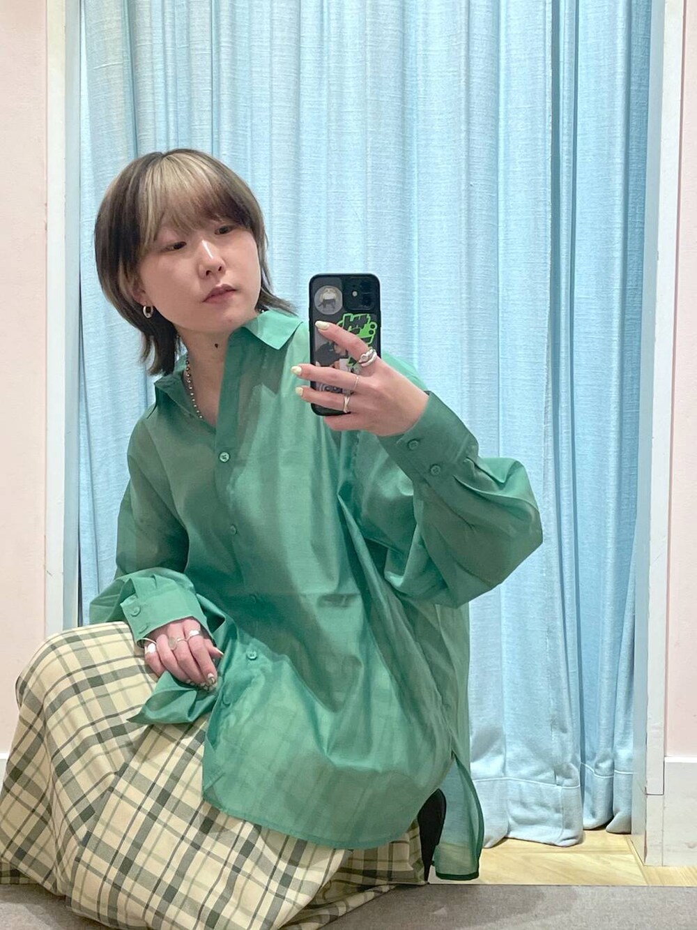 グリーン系のシャツ/ブラウス、ブラウン系のスニーカー、グリーン系のスカートを着用したレディースの春コーディネートの2枚目の写真