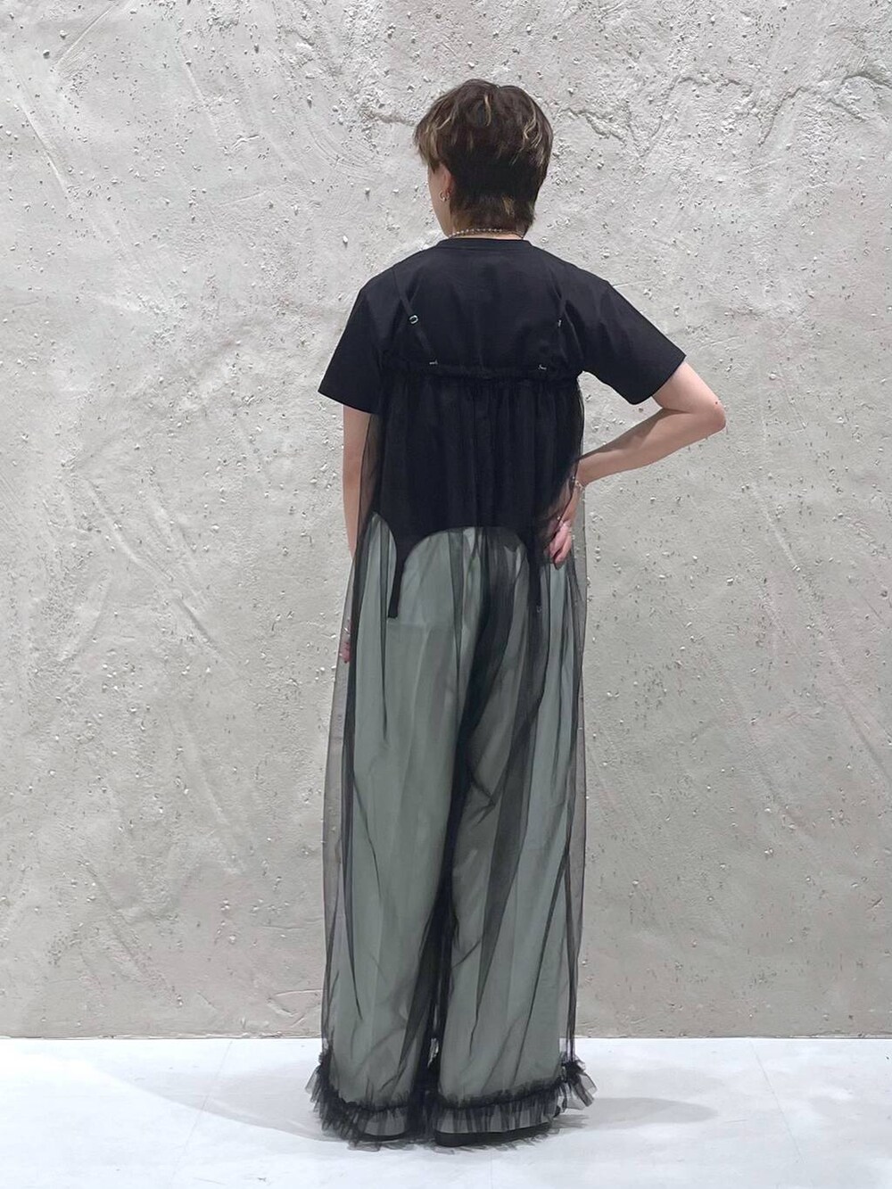 グリーン系のスラックス、ブラック系のTシャツ/カットソー、ブラック系のサロペット/オーバーオールを着用したレディースの夏コーディネートの3枚目の写真