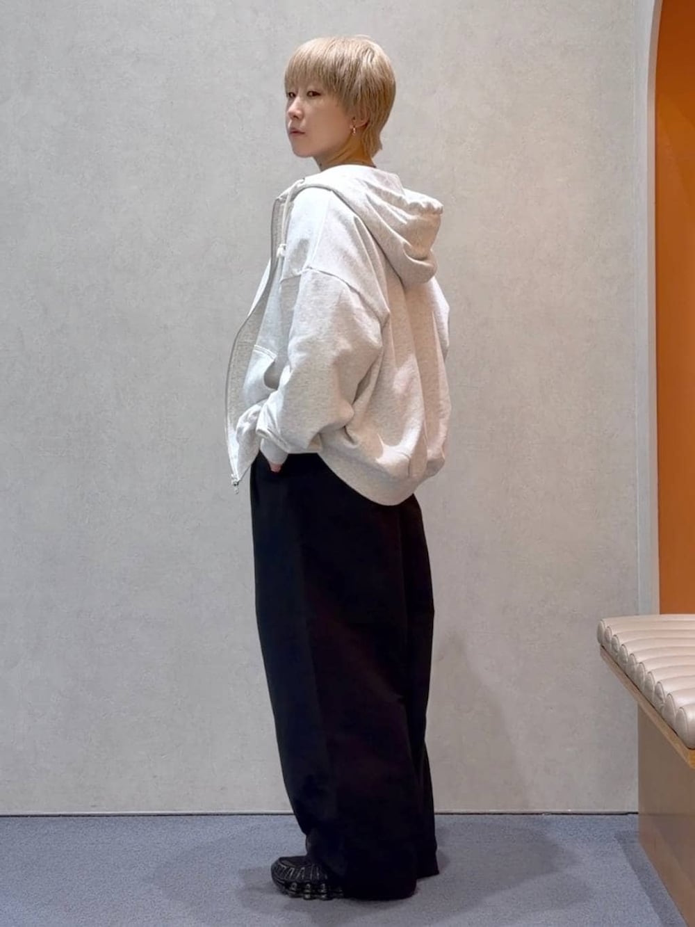 グレー系のパーカー、ブラック系のデニムパンツ、ブラウン系のTシャツ/カットソーを着用したメンズの春コーディネートの2枚目の写真