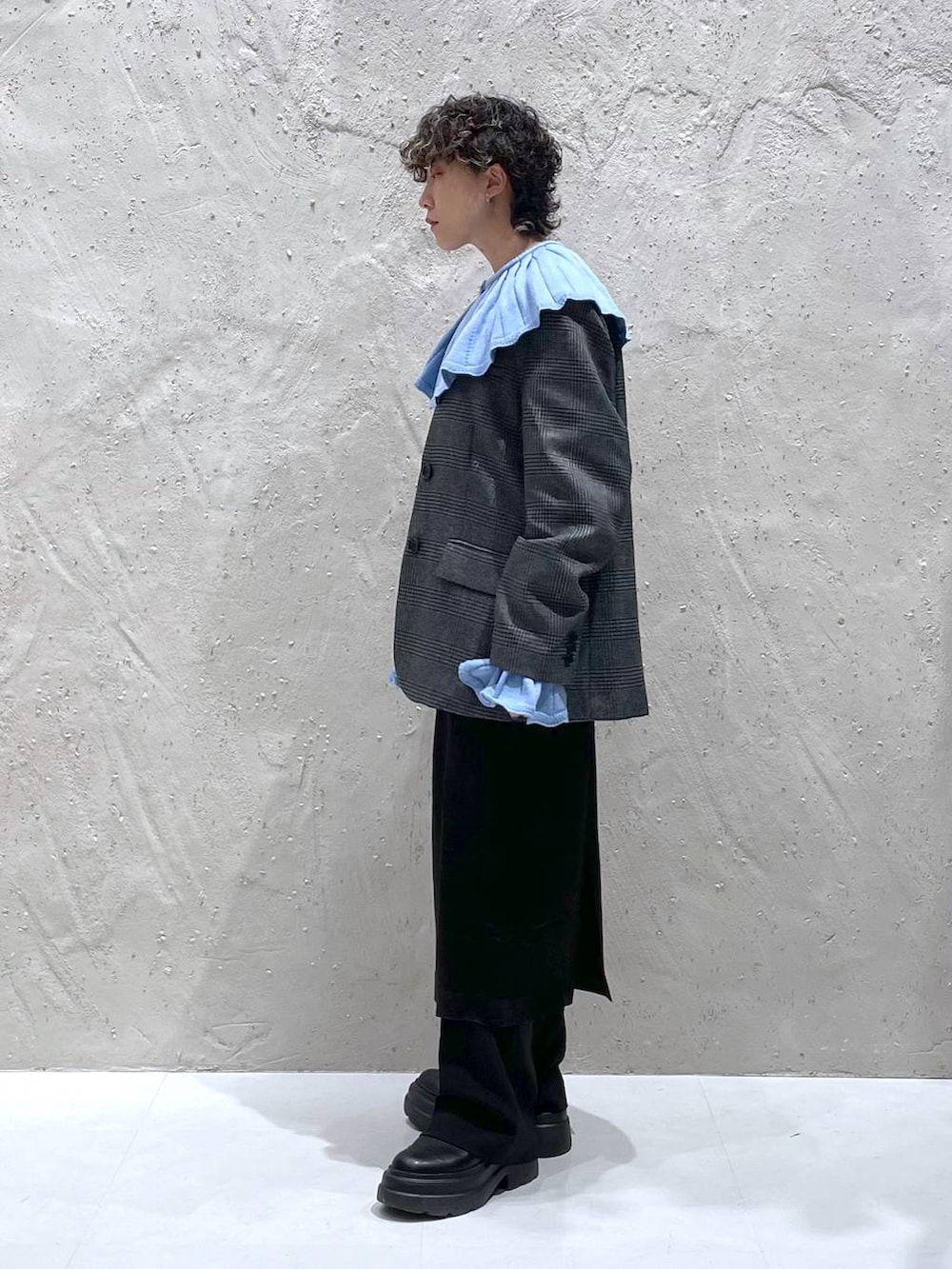 ブルー系のニット/セーター、ブラック系のブーツ、グレー系のテーラードジャケットを着用したレディースの冬コーディネートの2枚目の写真