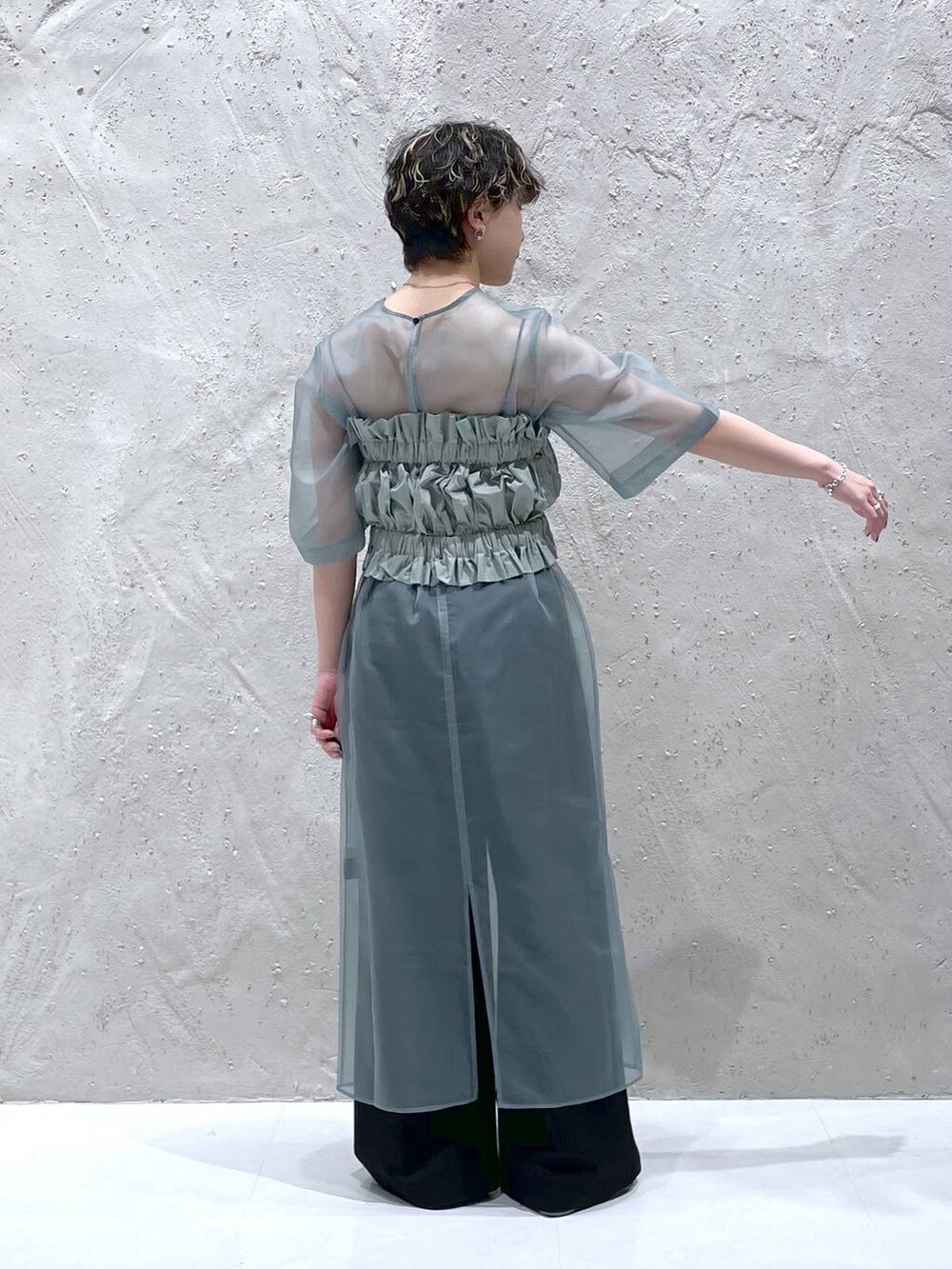 ブラック系のその他パンツ、グリーン系のワンピース、シルバー系のサンダルを着用したレディースの春コーディネートの3枚目の写真