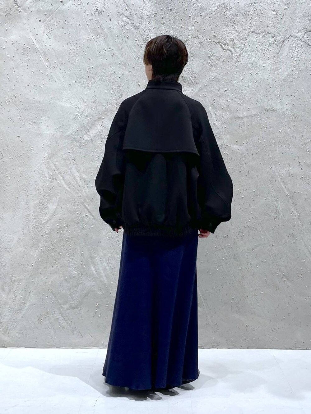 ブラック系のブルゾン、ブルー系のワンピース、ブラック系のローファーを着用したレディースの秋コーディネートの3枚目の写真