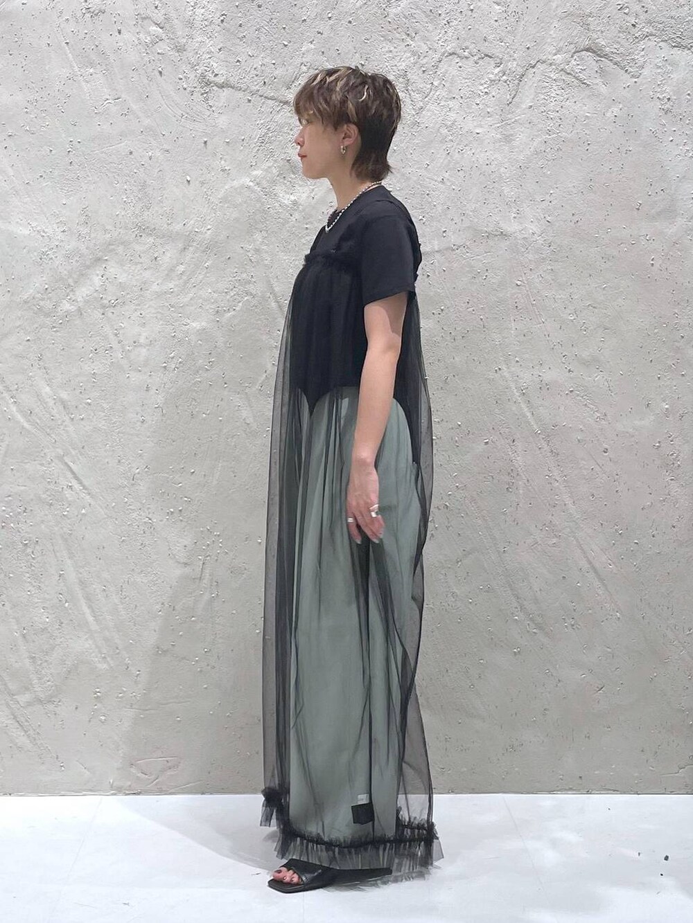グリーン系のスラックス、ブラック系のTシャツ/カットソー、ブラック系のサロペット/オーバーオールを着用したレディースの夏コーディネートの2枚目の写真