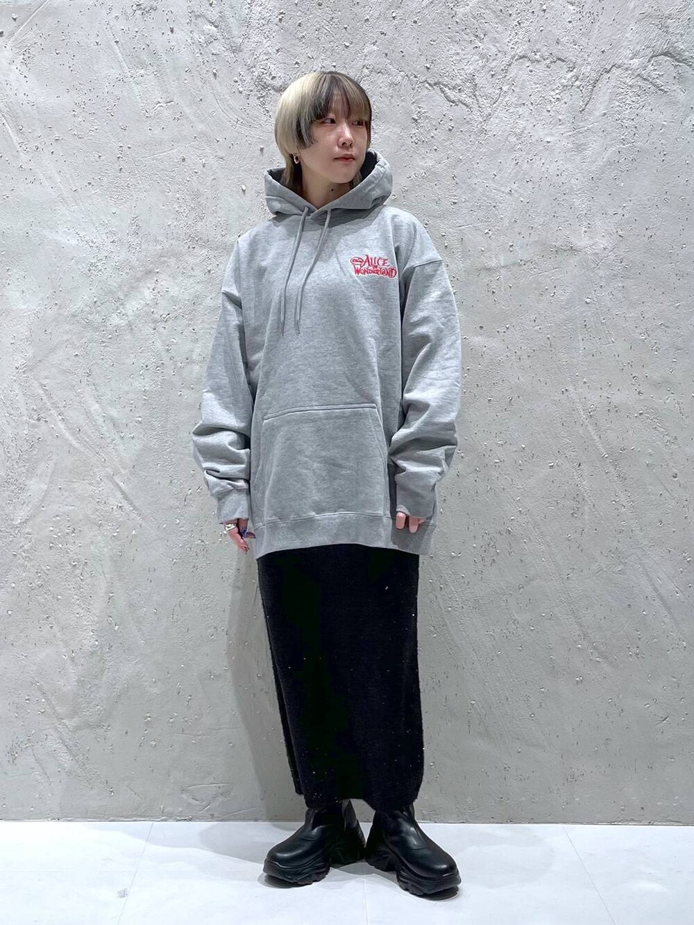 ブラック系のブーツ、ブラック系のスカート、グレー系のスウェットを着用したレディースの冬コーディネートの2枚目の写真