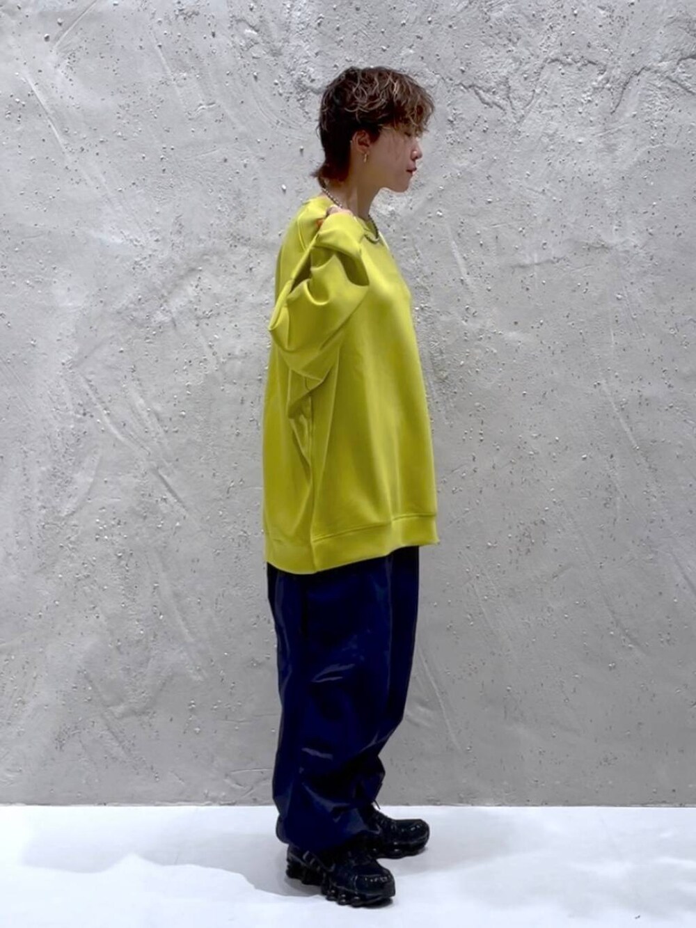 イエロー系のTシャツ/カットソー、ブルー系のカーゴパンツを着用したレディースの秋コーディネートの4枚目の写真