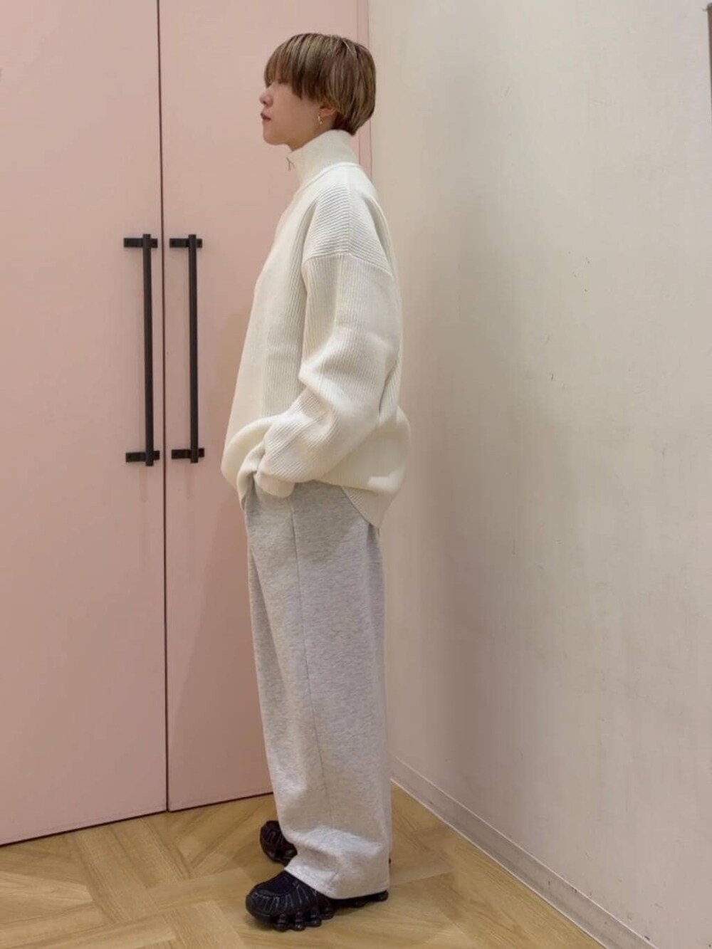 グレー系のスウェットパンツ、ホワイト系のニット/セーターを着用したレディースの冬コーディネートの2枚目の写真