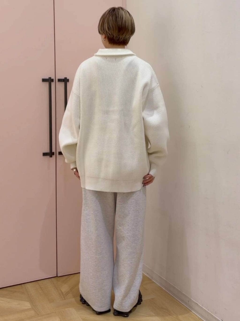 グレー系のスウェットパンツ、ホワイト系のニット/セーターを着用したレディースの冬コーディネートの5枚目の写真