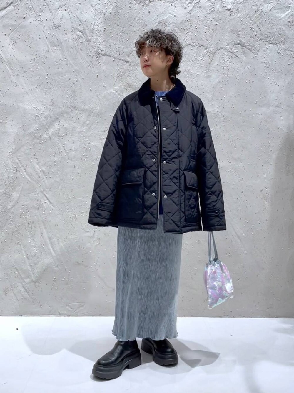 ブルー系のTシャツ/カットソー、ブラック系のブーツ、ホワイト系のハンドバッグを着用したレディースの冬コーディネートの5枚目の写真