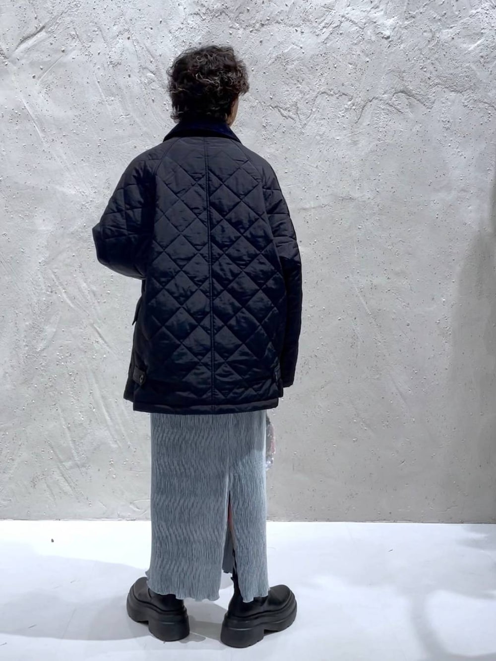 ブルー系のTシャツ/カットソー、ブラック系のブーツ、ホワイト系のハンドバッグを着用したレディースの冬コーディネートの3枚目の写真