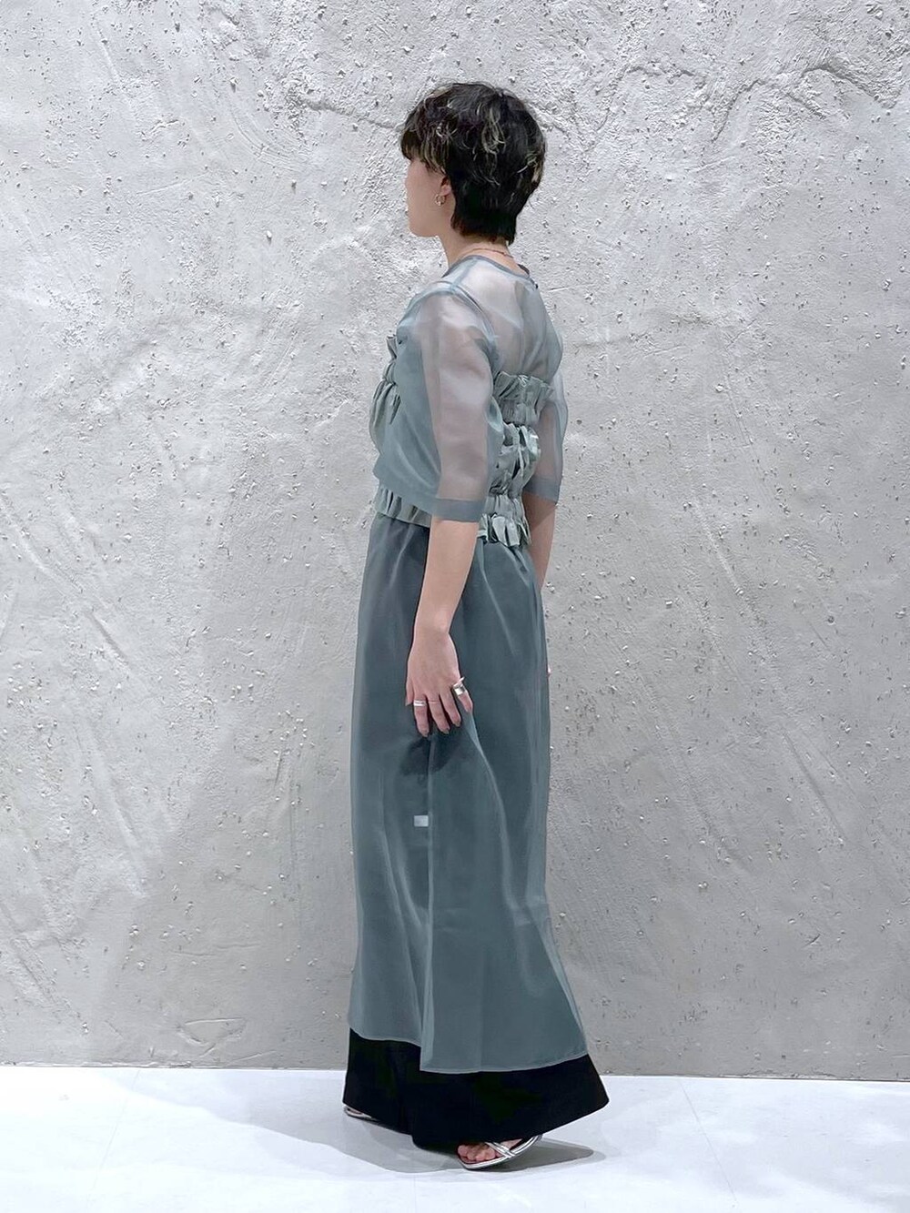 ブラック系のその他パンツ、グリーン系のワンピース、シルバー系のサンダルを着用したレディースの春コーディネートの2枚目の写真