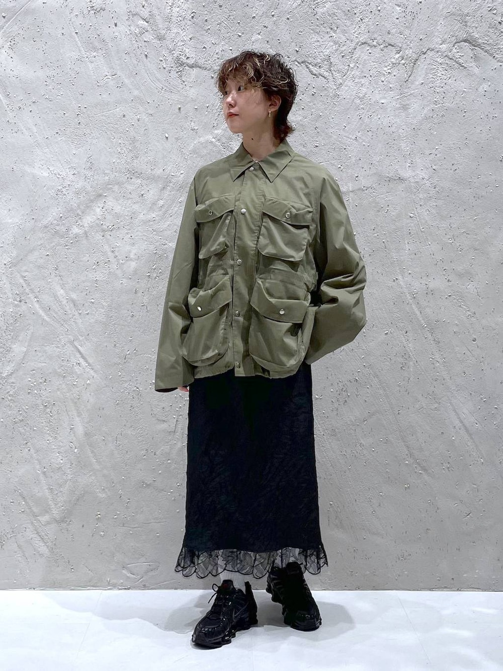 グリーン系のブルゾン、ブラック系のスカートを着用したレディースの夏コーディネートの6枚目の写真