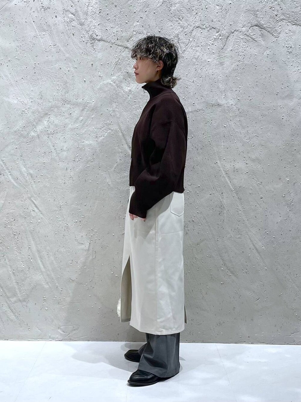 グレー系のその他パンツ、ベージュ系のスカート、ホワイト系のハンドバッグを着用したレディースの春コーディネートの2枚目の写真