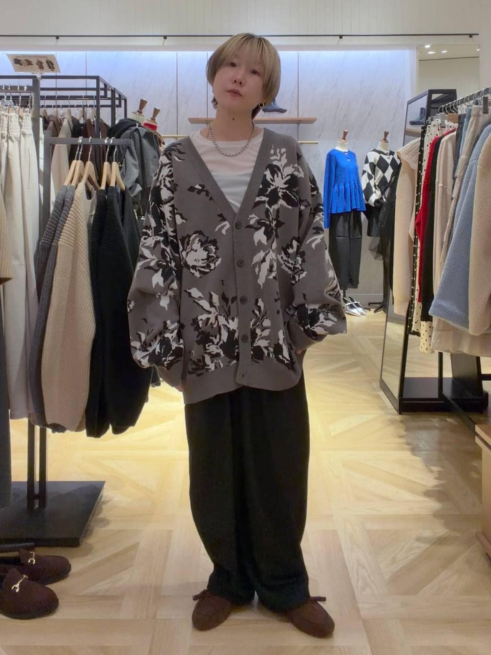 グレー系のカーディガン/ボレロ、グレー系のその他パンツ、ブラウン系のモカシン/デッキシューズを着用したレディースの秋コーディネートの5枚目の写真