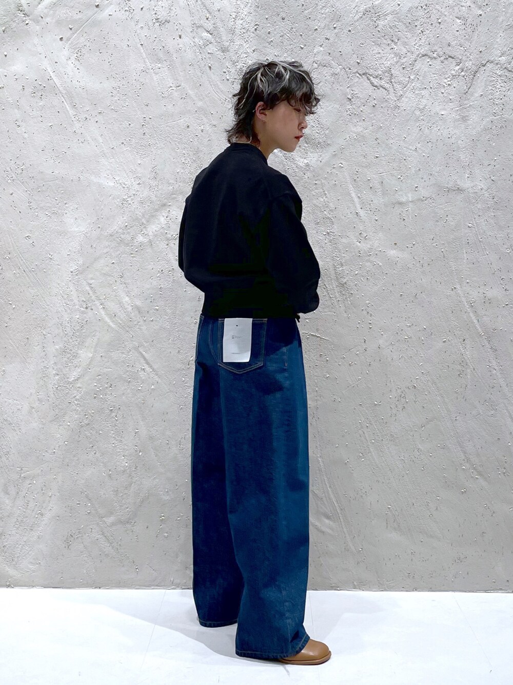 ブラック系のカーディガン/ボレロ、ブラック系のデニムパンツ、ブラウン系のサンダルを着用したレディースの春コーディネートの2枚目の写真