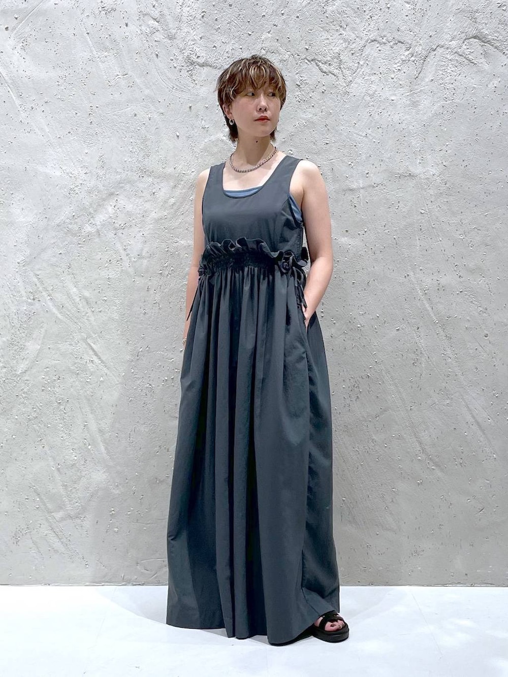 ブラック系のスニーカー、グレー系のワンピースを着用したレディースの夏コーディネートの5枚目の写真