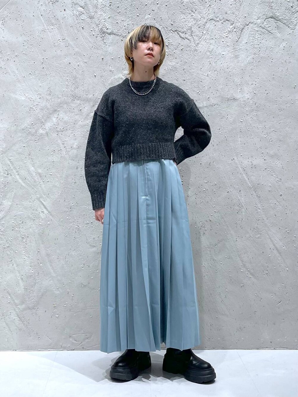 グレー系のニット/セーター、ブルー系のスカートを着用したレディースの秋コーディネートの5枚目の写真