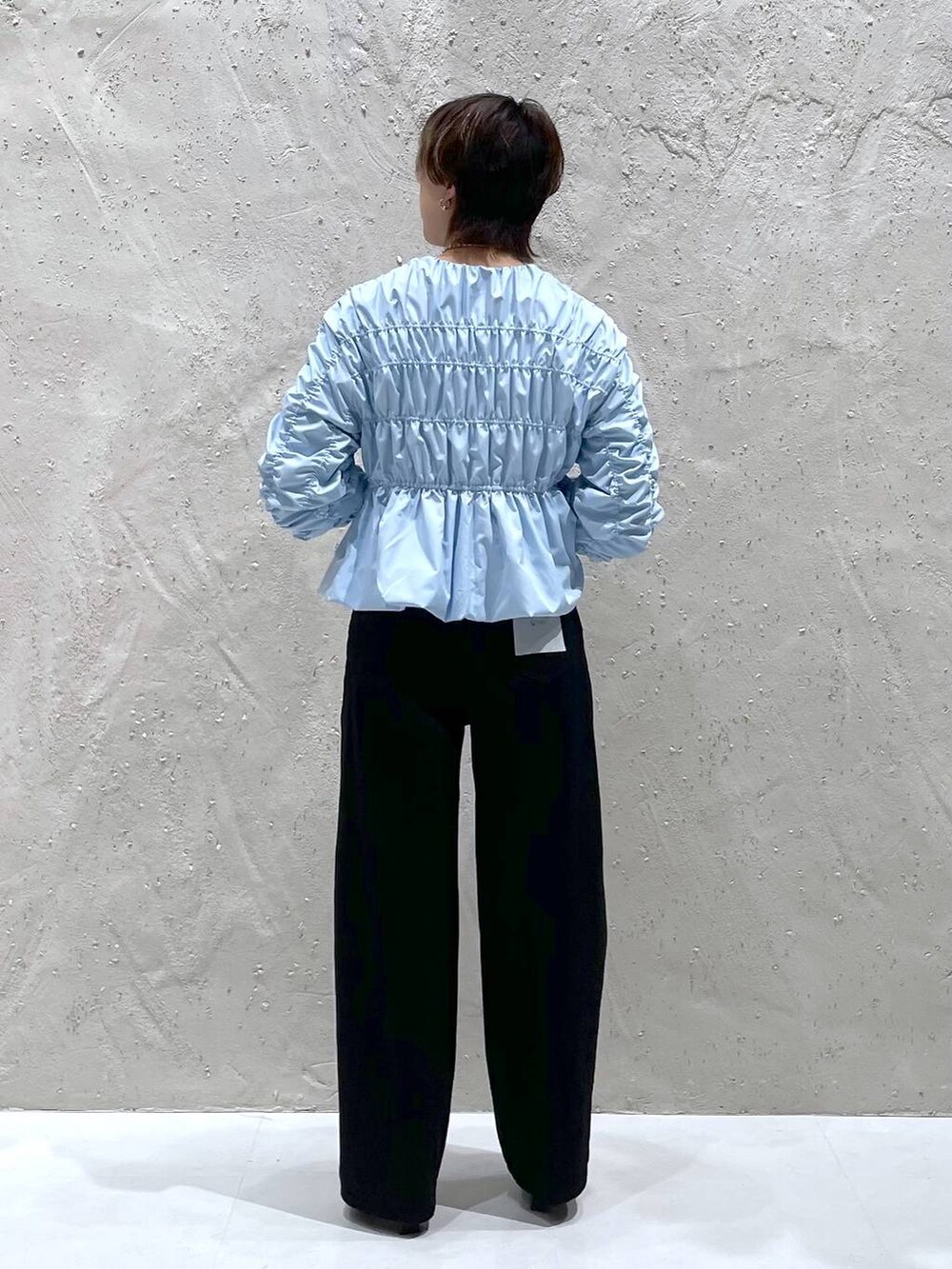 ブラック系のブーツ、ブラック系のデニムパンツ、ブルー系のシャツ/ブラウスを着用したレディースの秋コーディネートの3枚目の写真