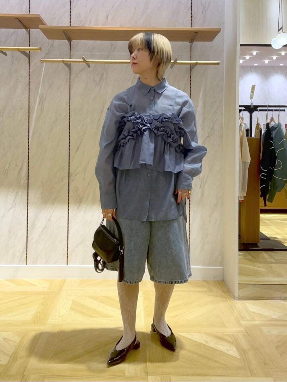 ブルー系のシャツ/ブラウス、ブルー系のキャミソール、ブラック系のショルダーバッグを着用したレディースの春コーディネートの5枚目の写真