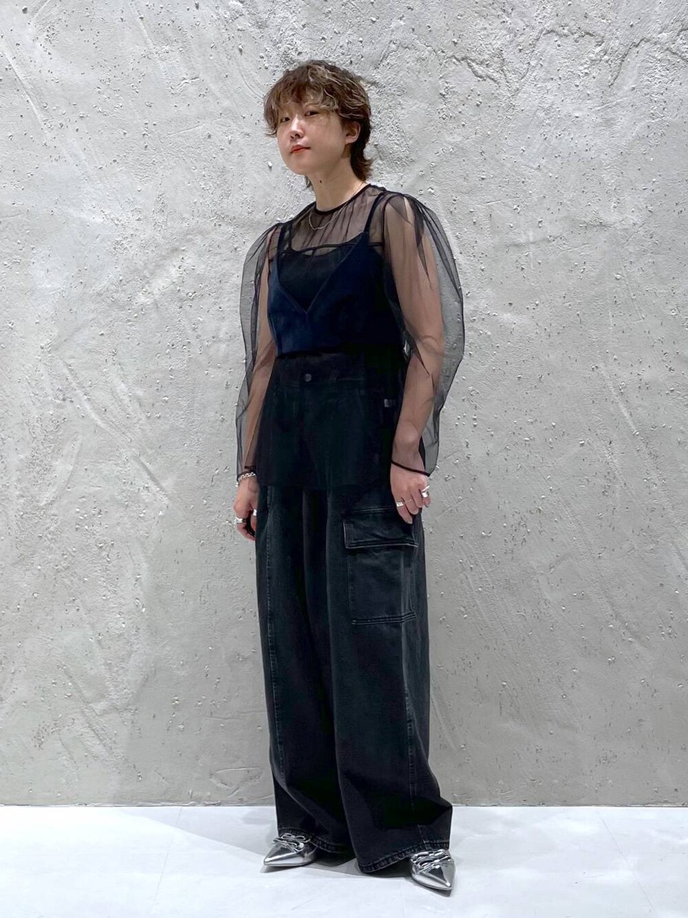 ブラック系のデニムパンツ、シルバー系のパンプス、ブルー系のベストを着用したレディースの夏コーディネートの6枚目の写真