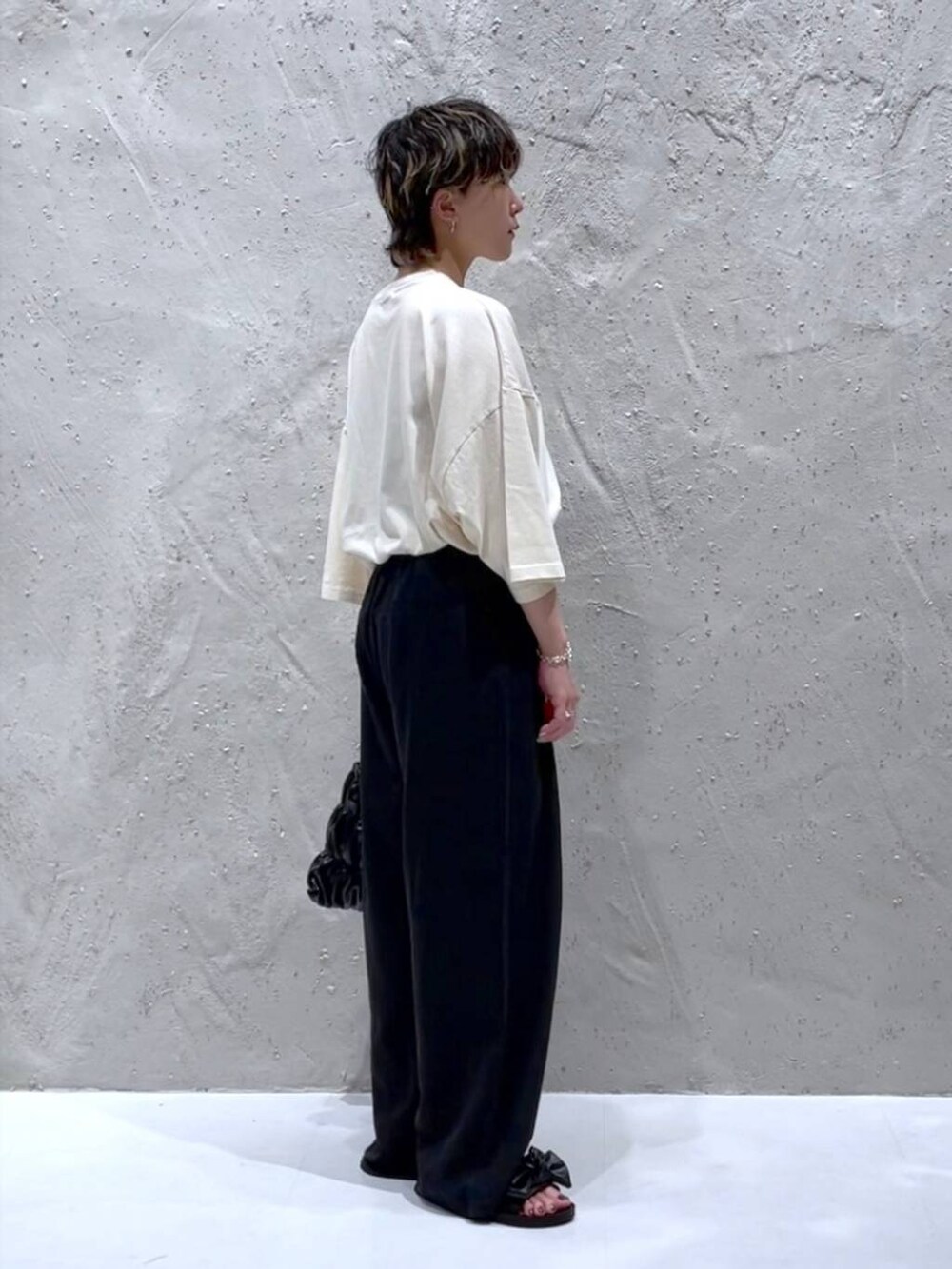 ホワイト系のTシャツ/カットソー、ブラック系のサンダル、ブラック系のショルダーバッグを着用したレディースの夏コーディネートの4枚目の写真