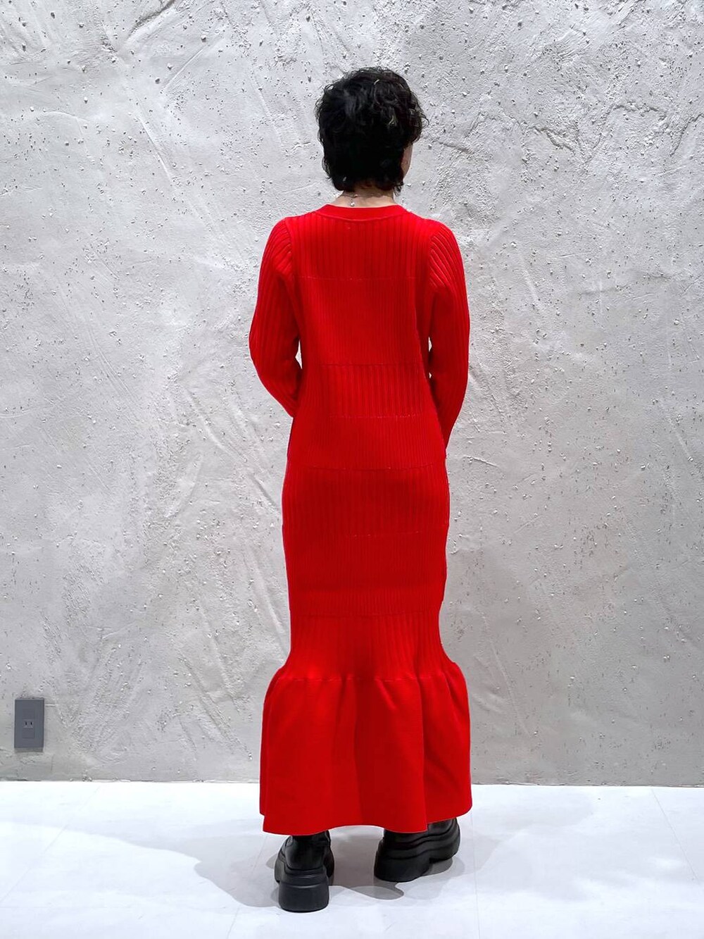 ブラック系のブーツ、ブラウン系のその他アウター、レッド系のワンピースを着用したレディースの冬コーディネートの8枚目の写真