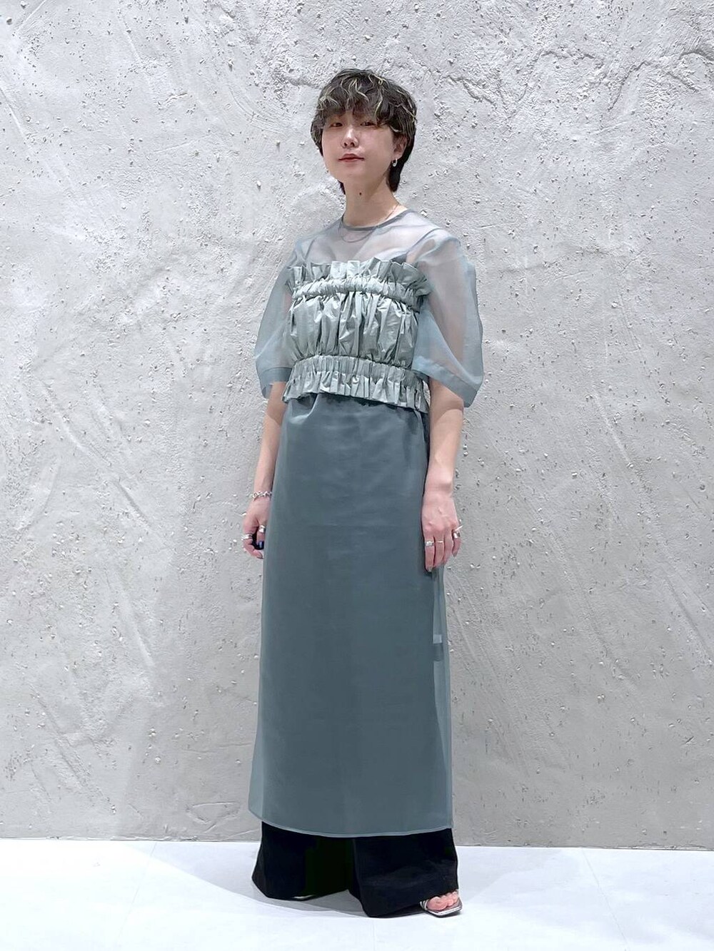 ブラック系のその他パンツ、グリーン系のワンピース、シルバー系のサンダルを着用したレディースの春コーディネートの7枚目の写真