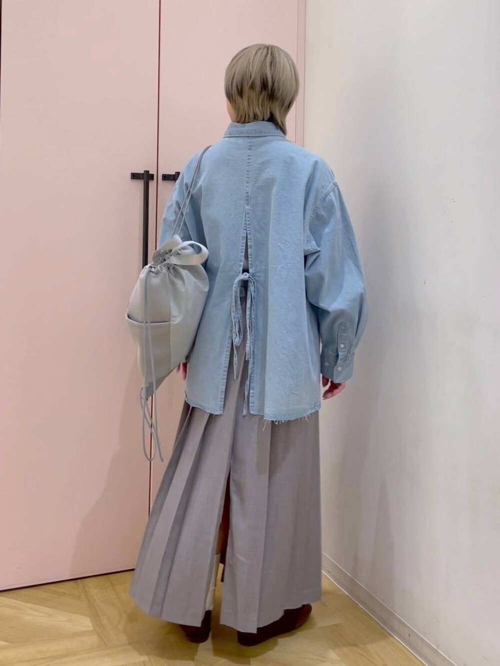 ブラウン系のスニーカー、グレー系のバックパック/リュック、ブルー系のシャツ/ブラウスを着用したレディースの冬コーディネートの3枚目の写真