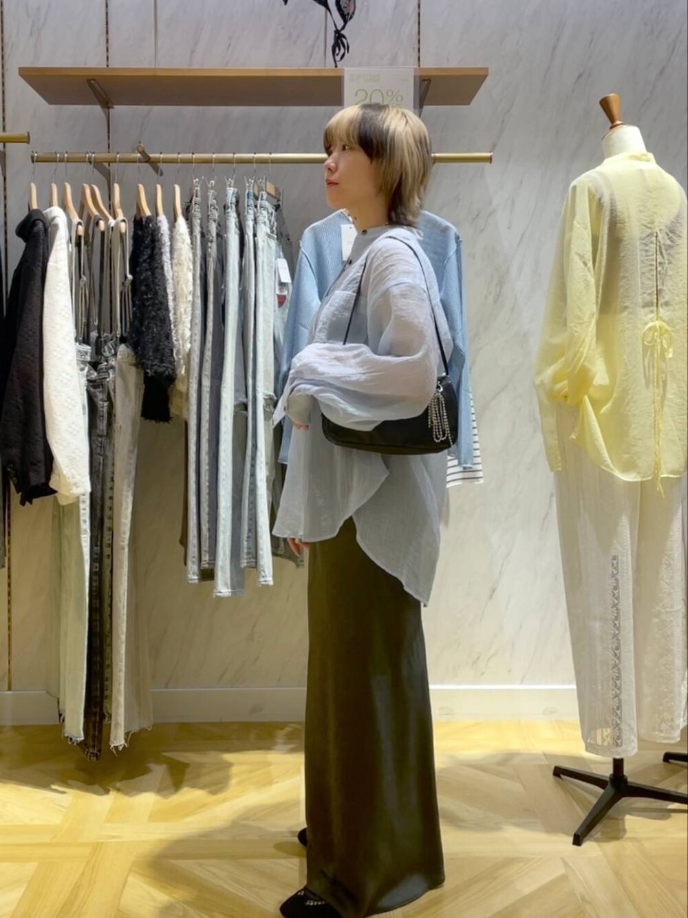 ブラック系のトートバッグ、ブラック系のスニーカー、グレー系のスカートを着用したレディースの春コーディネートの2枚目の写真