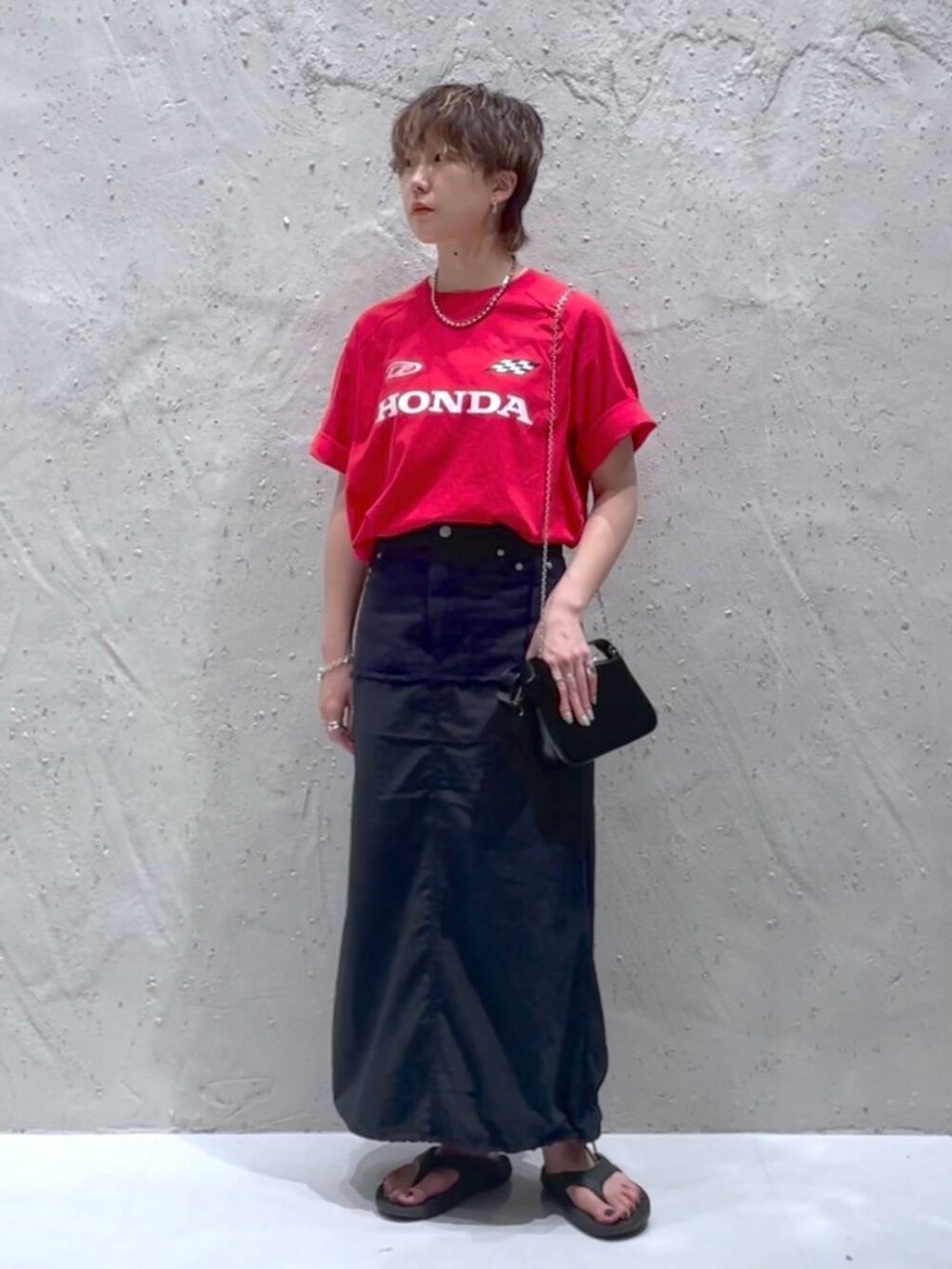 ブラック系のデニムスカート、レッド系のTシャツ/カットソーを着用したレディースの夏コーディネートの5枚目の写真