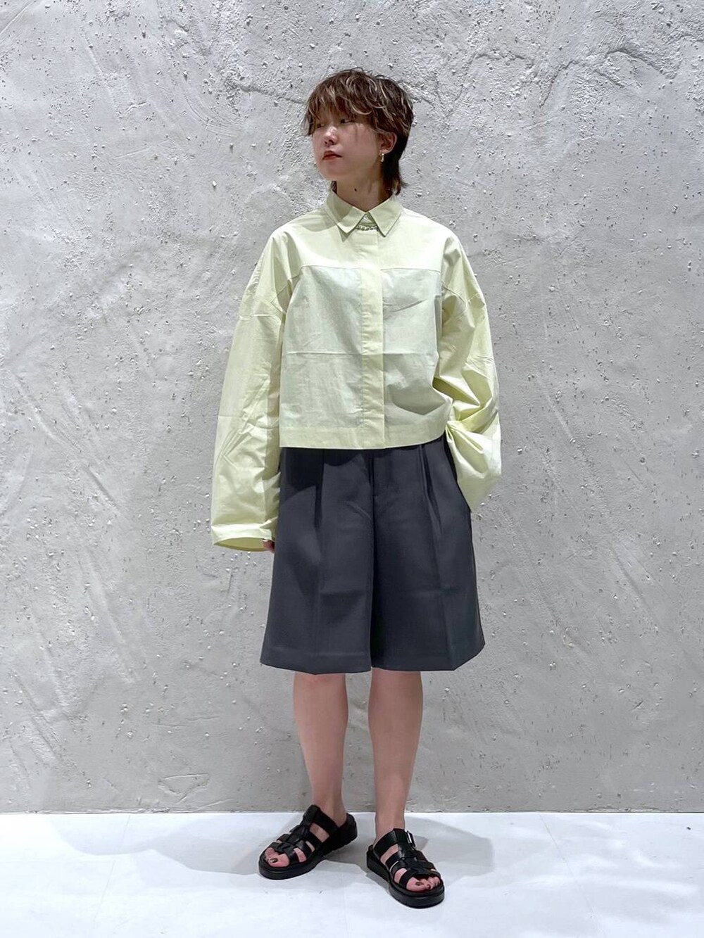 ブラック系のスニーカー、グレー系のその他パンツ、イエロー系のシャツ/ブラウスを着用したレディースの夏コーディネートの6枚目の写真