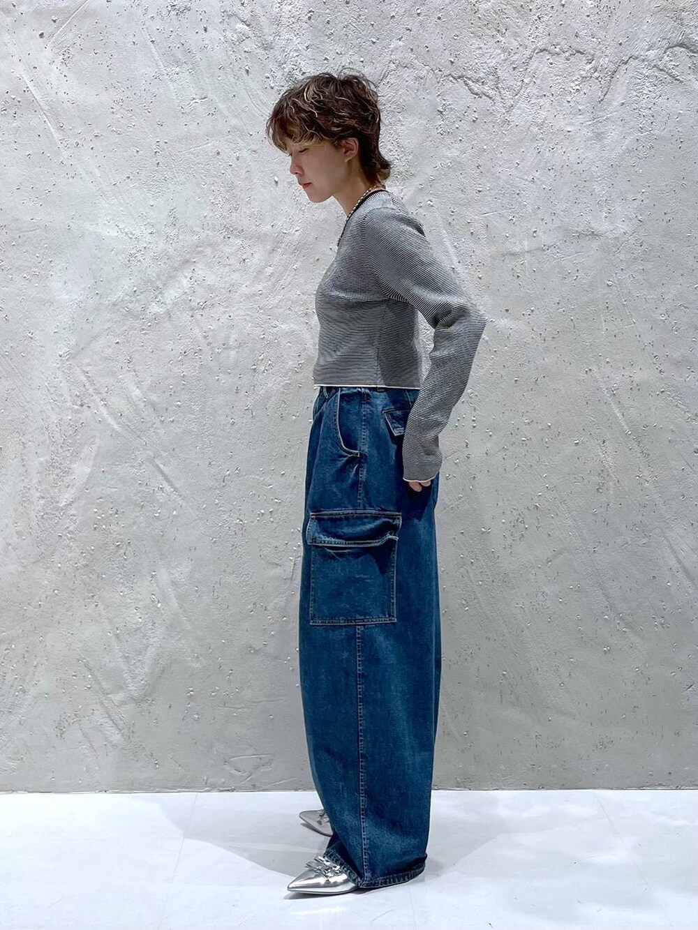 ブルー系のデニムパンツ、シルバー系のパンプス、その他のニット/セーターを着用したレディースの夏コーディネートの2枚目の写真