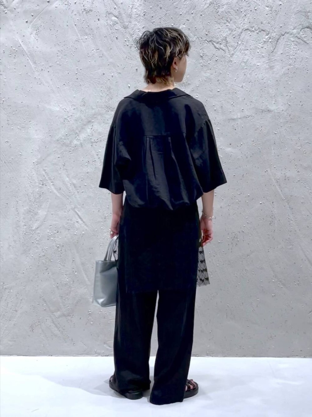 ブラック系のTシャツ/カットソー、ブラック系のスニーカー、グレー系のスラックスを着用したレディースの夏コーディネートの3枚目の写真