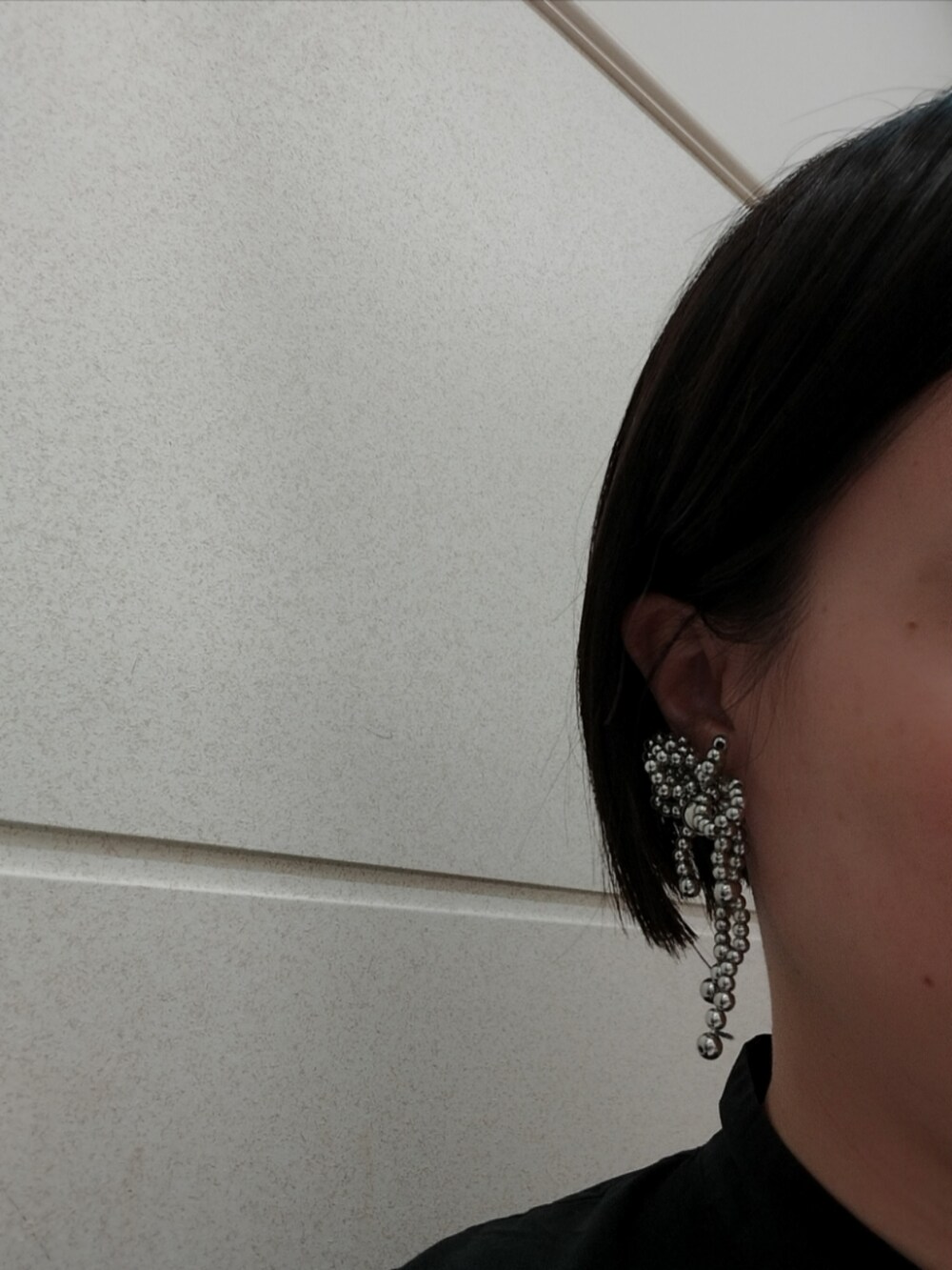 ブラック系のシャツ/ブラウス、グレー系のパンツ、シルバー系のショルダーバッグを着用したレディースの夏コーディネートの3枚目の写真