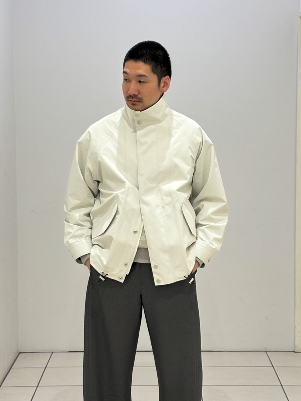 ホワイト系のその他アウター、グレー系のスラックス、グレー系のスウェットを着用したメンズの春コーディネートの2枚目の写真