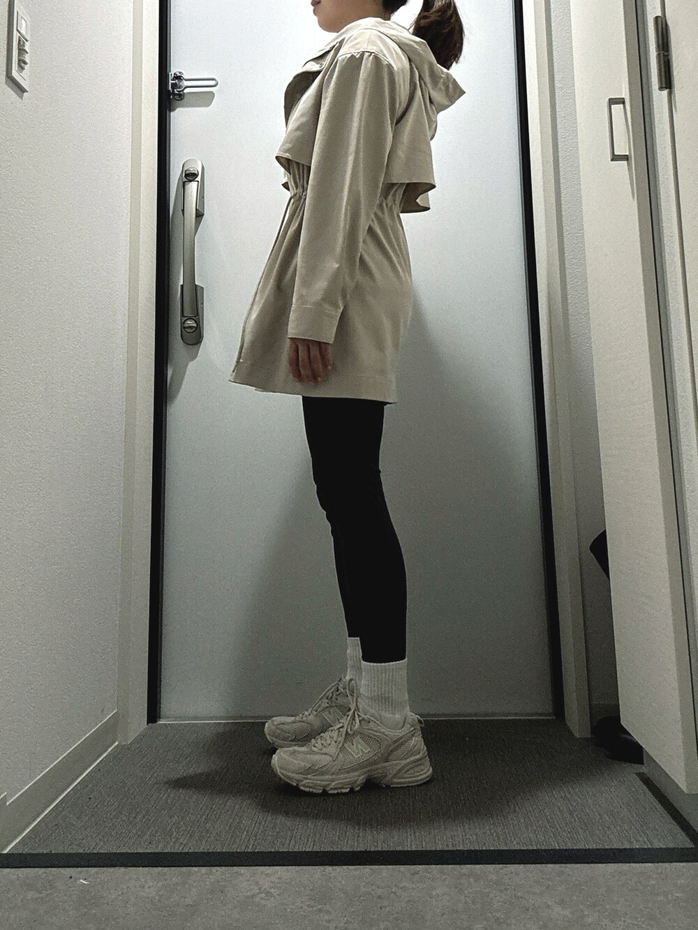 ホワイト系のスニーカー、ベージュ系のマウンテンパーカーを着用したレディースの春コーディネートの2枚目の写真