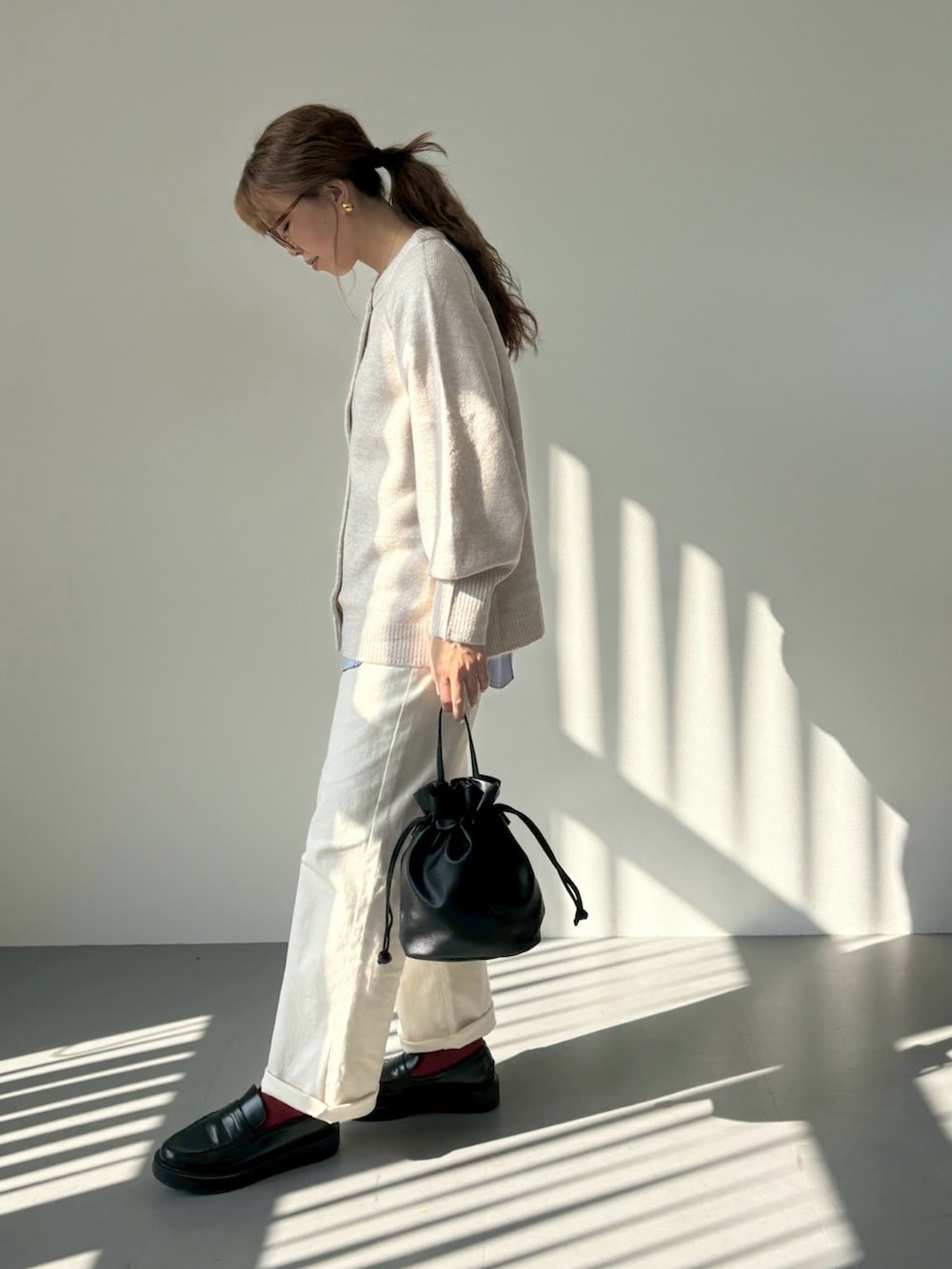 ベージュ系のニット/セーター、ホワイト系のTシャツ/カットソー、ブラック系のローファーを着用したレディースの秋コーディネートの2枚目の写真