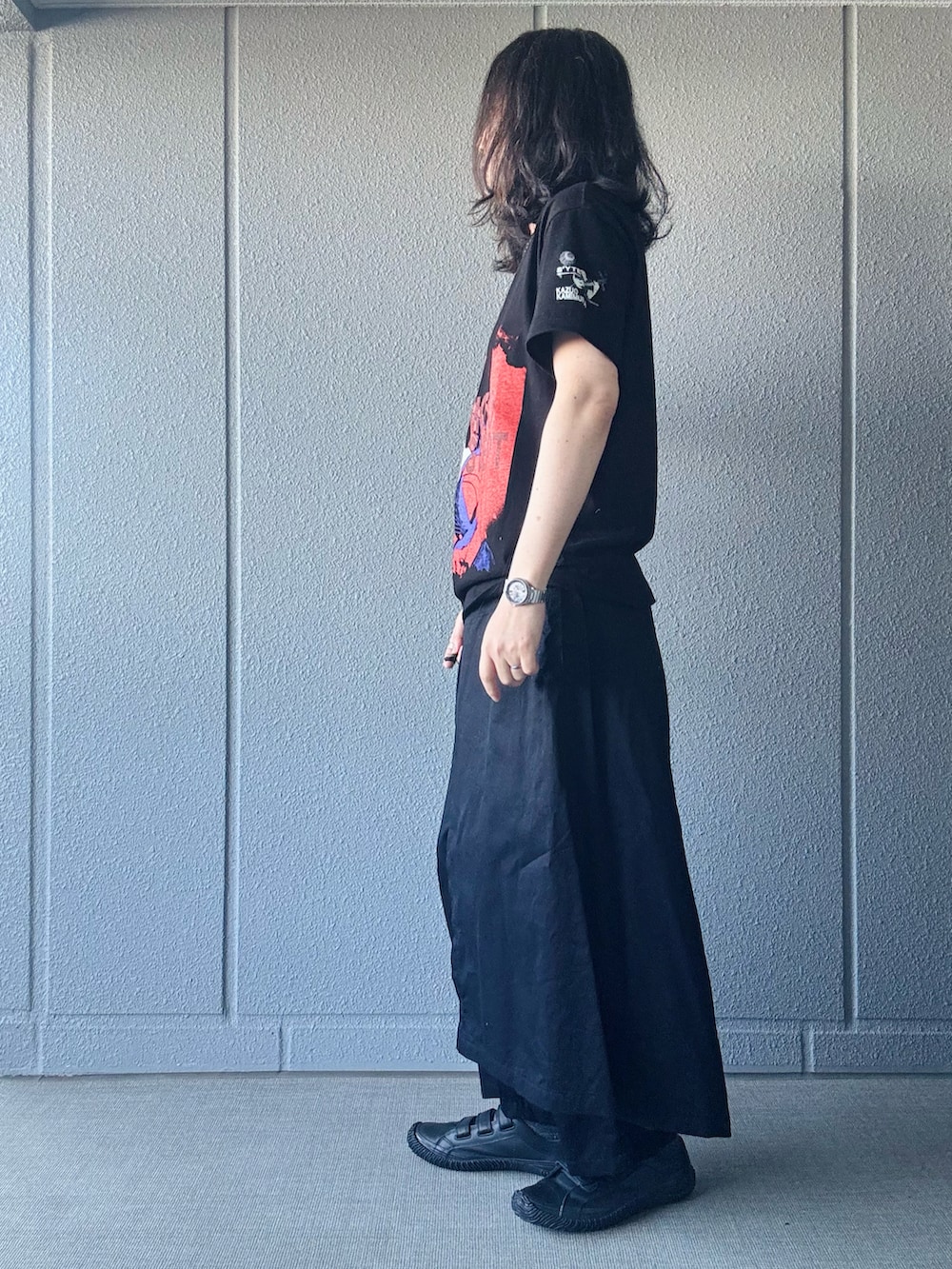 ブラック系のTシャツ/カットソー、ブラック系のパンツ、ブラック系のスニーカーを着用したメンズの春コーディネートの2枚目の写真