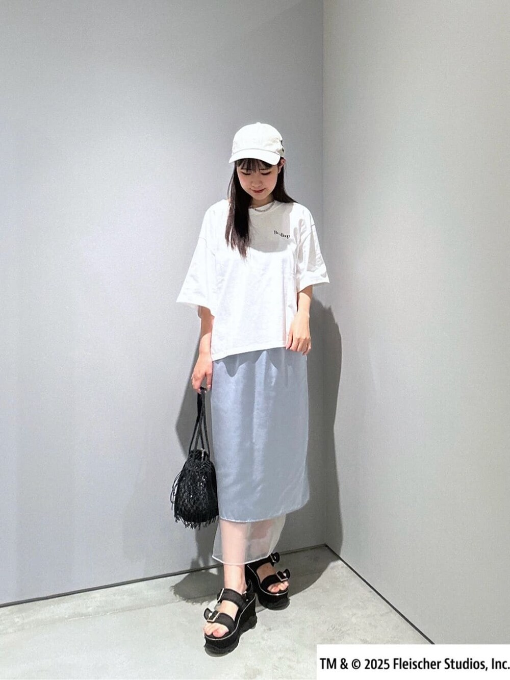 ホワイト系のTシャツ/カットソー、ブルー系のスカート、ブラック系のハンドバッグを着用したレディースの夏コーディネートの4枚目の写真