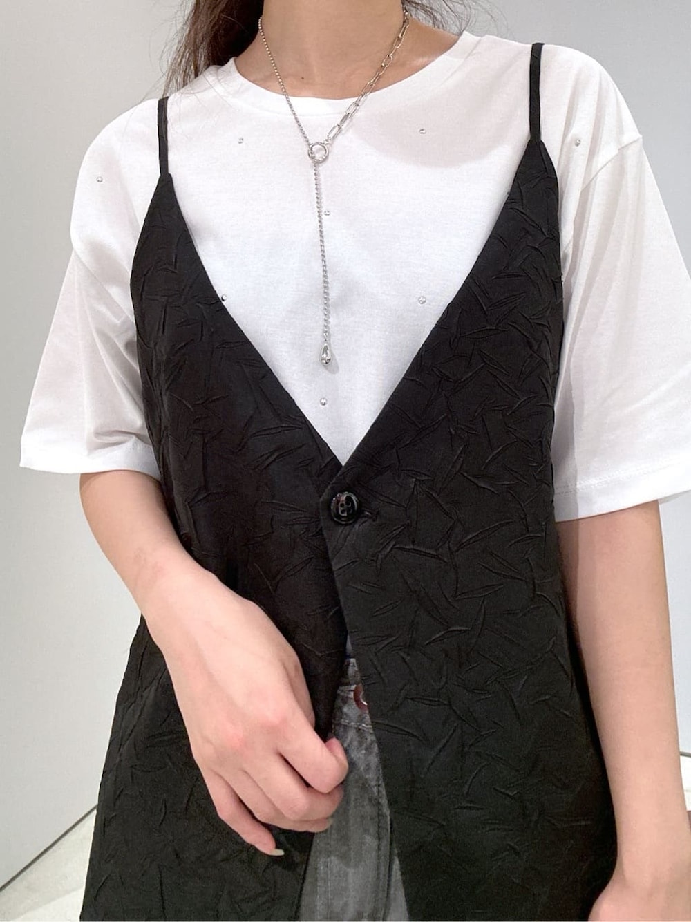 ホワイト系のTシャツ/カットソー、ブラック系のベスト、グレー系のデニムパンツを着用したレディースの夏コーディネートの7枚目の写真