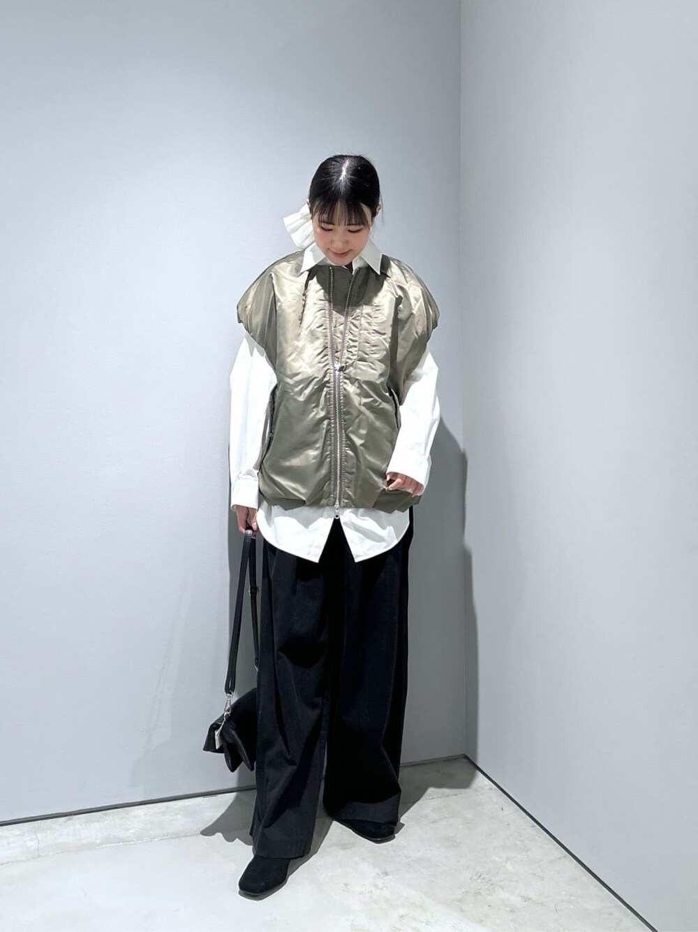 グリーン系のブルゾン、ホワイト系のシャツ/ブラウス、ブラック系のその他パンツを着用したレディースの冬コーディネートの4枚目の写真