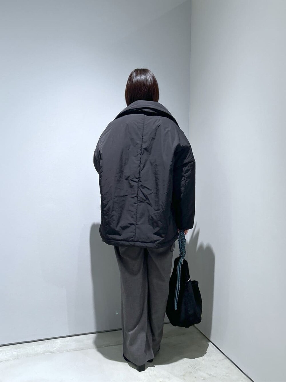 ブラック系のその他アウター、グレー系のその他パンツ、ブラック系のハンドバッグを着用したレディースの秋コーディネートの5枚目の写真