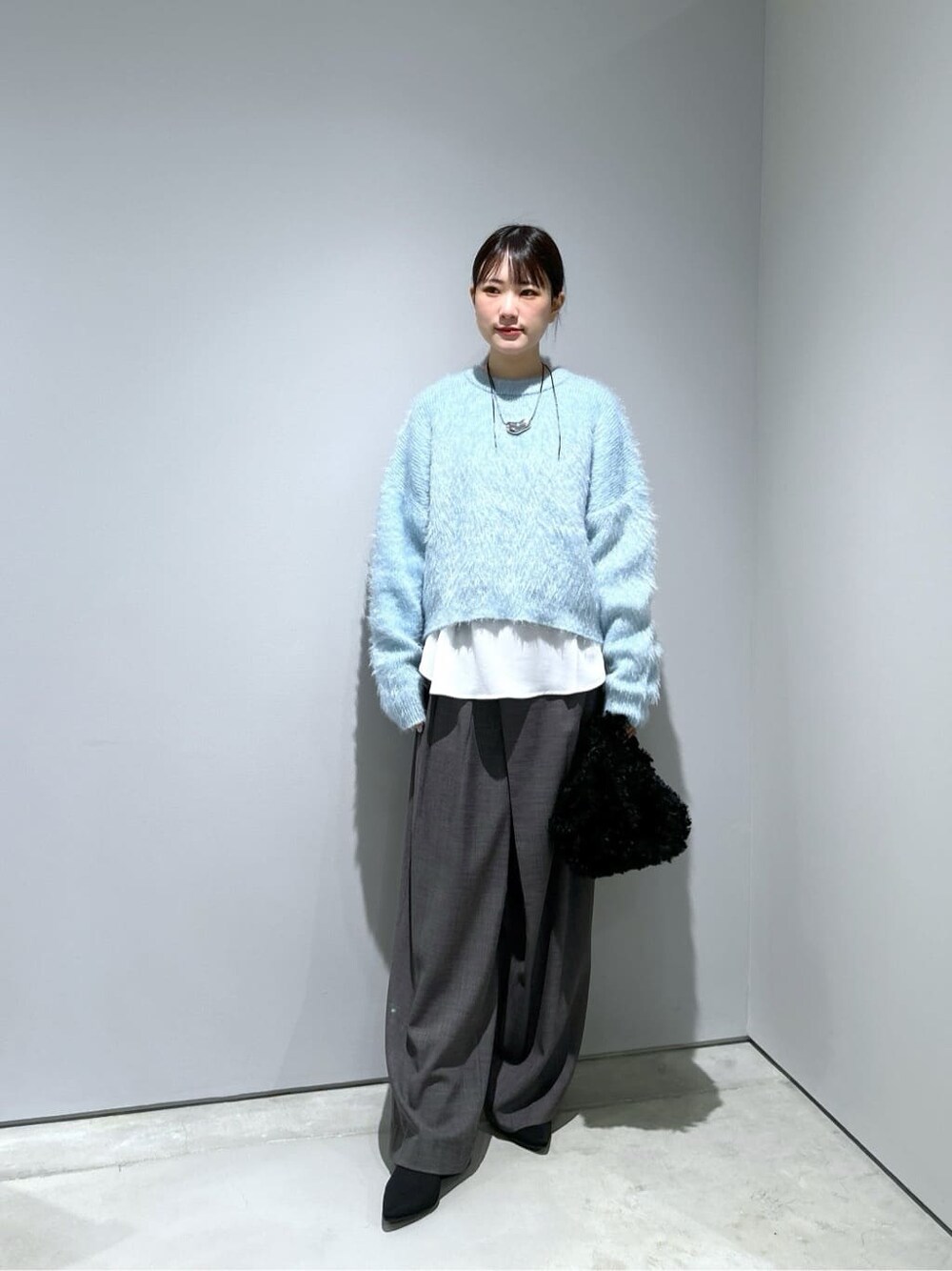 ブルー系のニット/セーター、ホワイト系のシャツ/ブラウス、グレー系のその他パンツを着用したレディースの秋コーディネートの3枚目の写真
