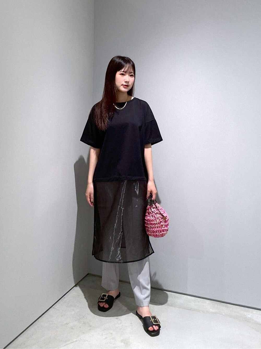 ブラック系のTシャツ/カットソー、グレー系のその他パンツ、ピンク系のハンドバッグを着用したレディースの夏コーディネートの2枚目の写真