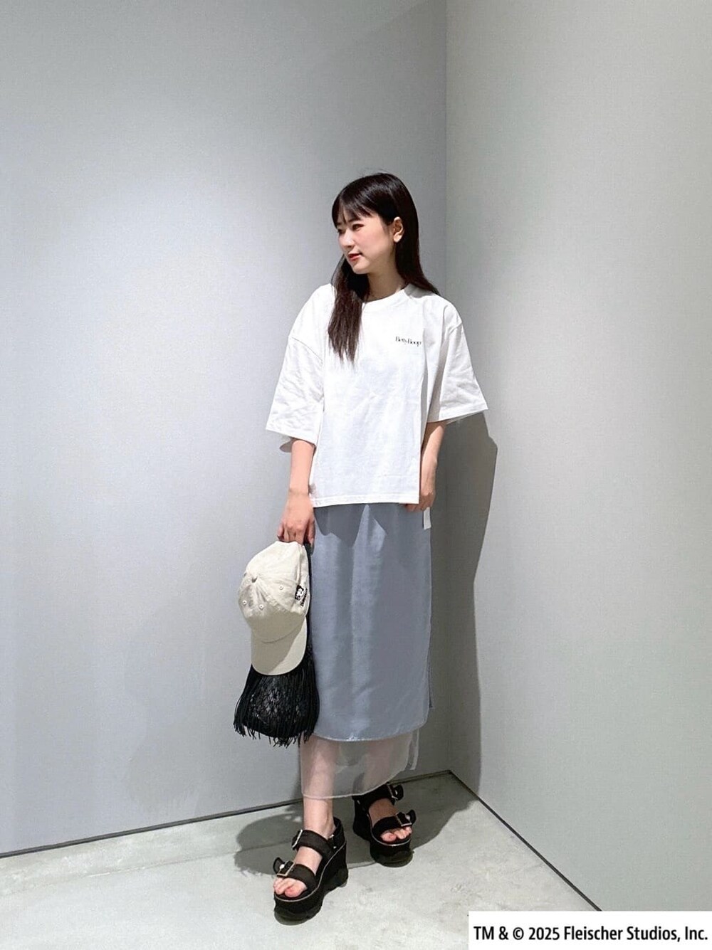 ホワイト系のTシャツ/カットソー、ブルー系のスカート、ブラック系のハンドバッグを着用したレディースの夏コーディネートの6枚目の写真