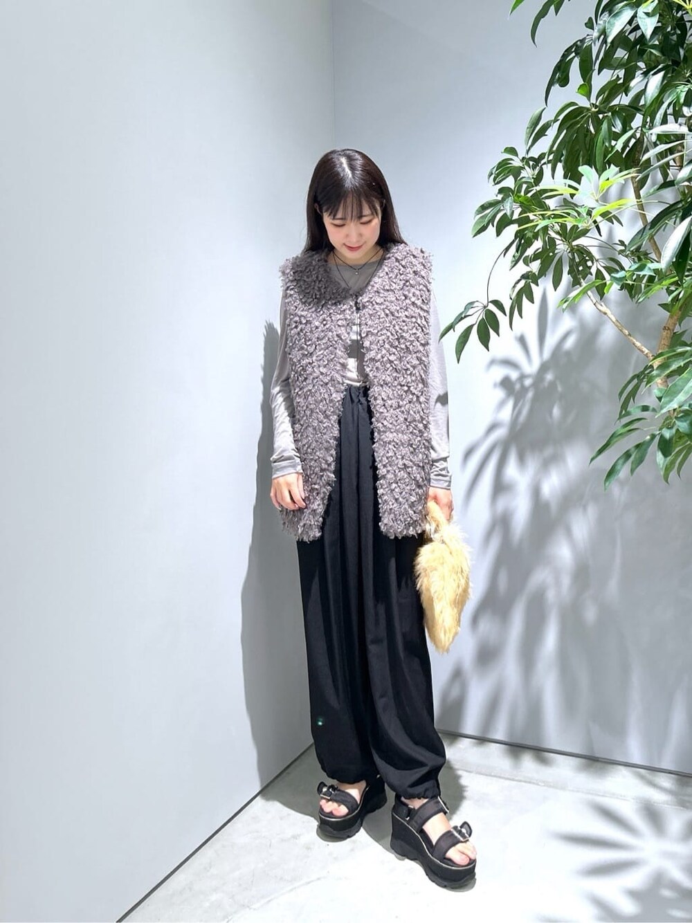 グレー系のTシャツ/カットソー、ブラック系のその他パンツ、ベージュ系のハンドバッグを着用したレディースの秋コーディネートの4枚目の写真