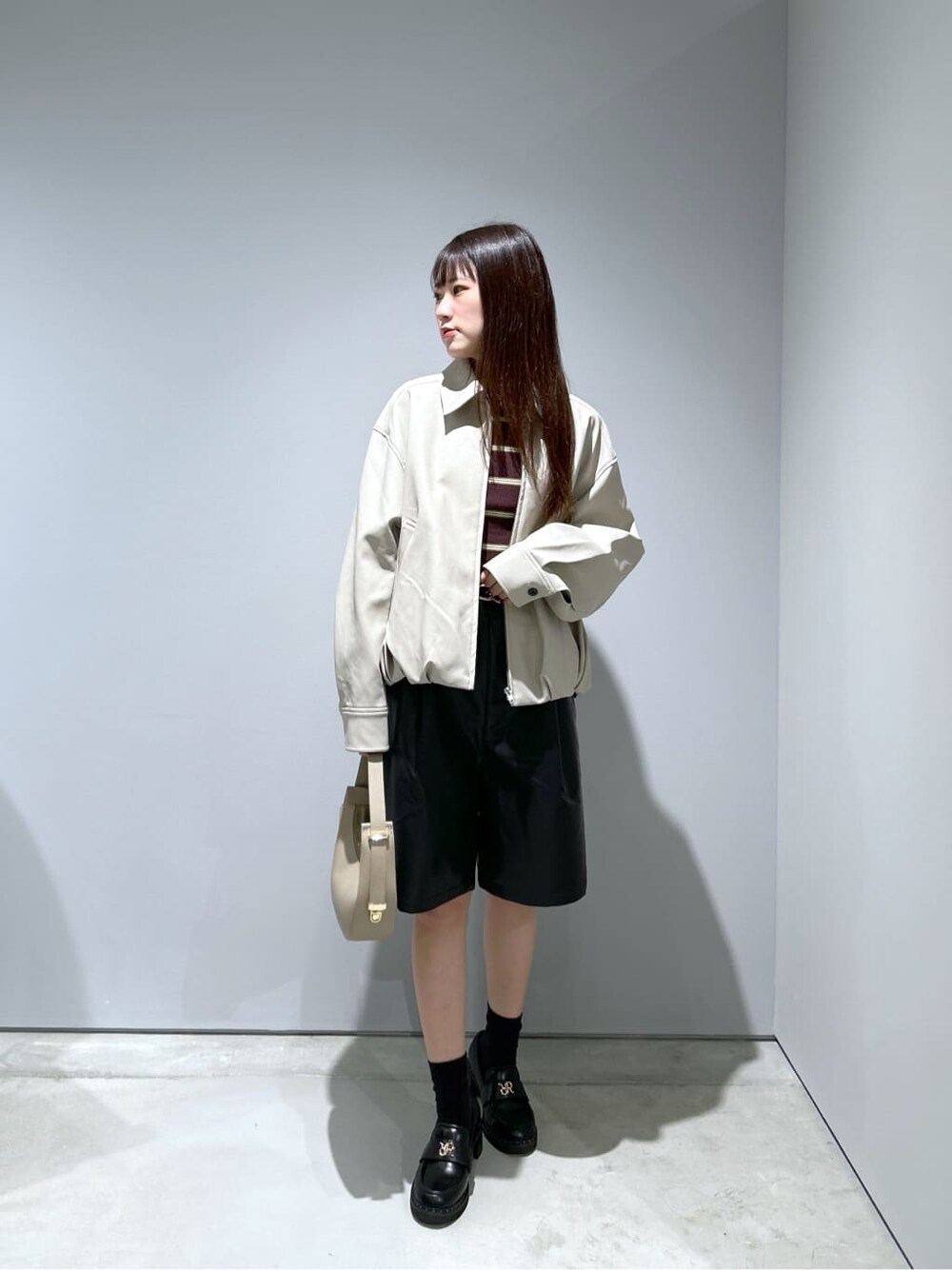 ベージュ系のブルゾン、ブラック系のその他パンツ、ベージュ系のショルダーバッグを着用したレディースの秋コーディネートの3枚目の写真