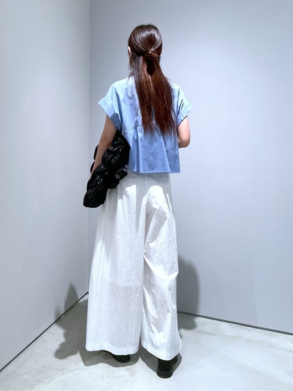 ブルー系のシャツ/ブラウス、ホワイト系のその他パンツ、ブラック系のトートバッグを着用したレディースの夏コーディネートの3枚目の写真