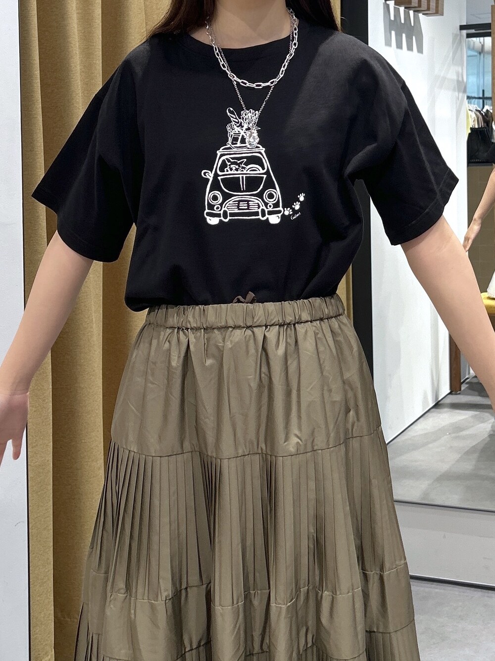 ブラック系のTシャツ/カットソー、グリーン系のスカート、シルバー系のハンドバッグを着用したレディースの夏コーディネートの7枚目の写真
